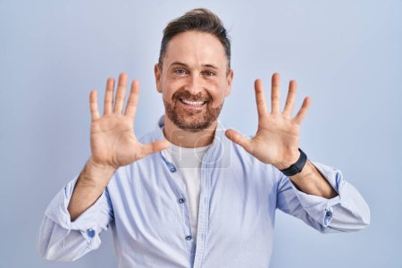 Photo for Middle age caucasian man standing over blue background showing and pointing up with fingers number ten while smiling confident and happy. - Royalty Free Image