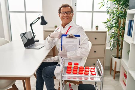 Photo for Senior doctor man working with samples pointing finger to one self smiling happy and proud - Royalty Free Image