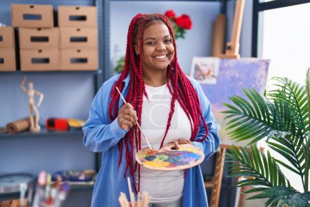 Téléchargez les photos : Artiste afro-américaine tenant pinceau et palette au studio d'art - en image libre de droit