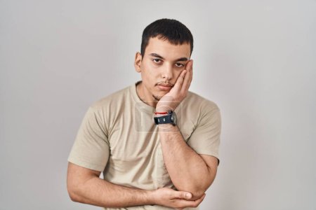 Téléchargez les photos : Jeune homme arabe portant t-shirt décontracté penser à la recherche fatigué et ennuyé avec des problèmes de dépression avec les bras croisés. - en image libre de droit
