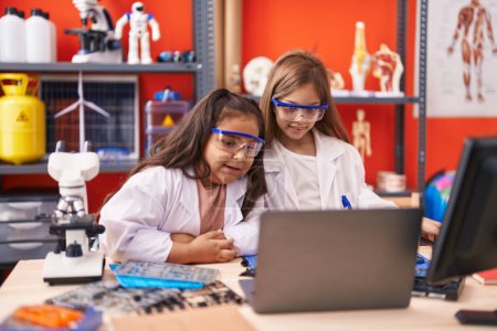 Foto de Dos estudiantes de niños usando portátil en el aula de laboratorio - Imagen libre de derechos