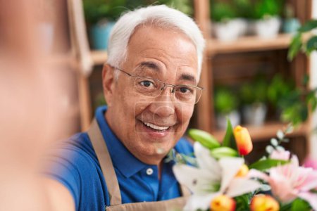 Photo for Middle age grey-haired man florist smiling confident make selfie by camera at florist - Royalty Free Image