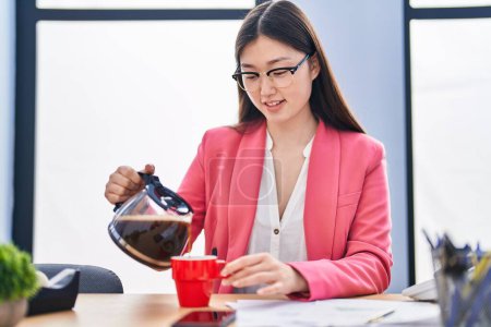 Téléchargez les photos : Chinese woman business worker pouring coffee on cup at office - en image libre de droit