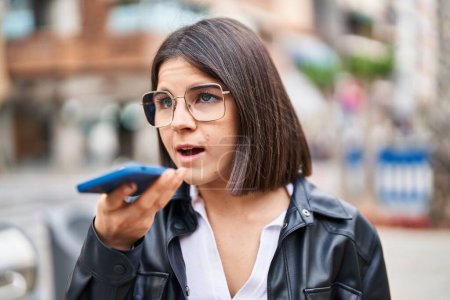 Téléchargez les photos : Young beautiful hispanic woman talking on the smartphone with serious expression at street - en image libre de droit