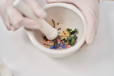 Téléchargez les photos : Young woman wearing scientist uniform mixing flowers at laboratory - en image libre de droit