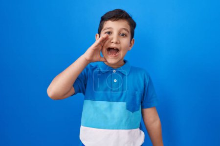 Photo for Little hispanic boy standing over blue background clueless and confused with open arms, no idea and doubtful face. - Royalty Free Image