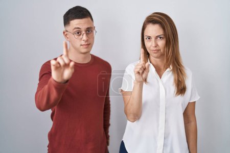 Téléchargez les photos : Mother and son standing together over isolated background pointing with finger up and angry expression, showing no gesture - en image libre de droit