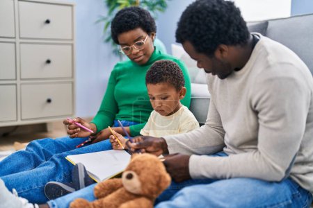 Photo for African american family drawing on notebook sitting on floor at home - Royalty Free Image