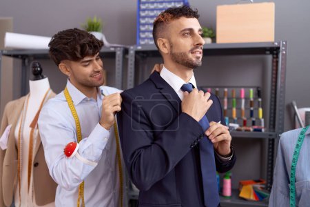 Téléchargez les photos : Two hispanic men tailor wearing jacket to client at atelier - en image libre de droit