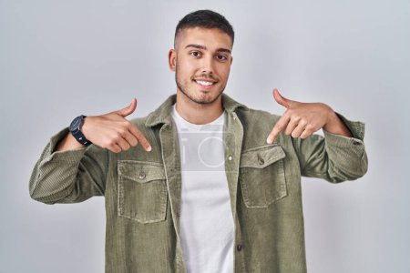 Photo for Young hispanic man standing over isolated background looking confident with smile on face, pointing oneself with fingers proud and happy. - Royalty Free Image