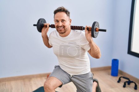 Foto de Young caucasian man smiling confident training legs exercise at sport center - Imagen libre de derechos