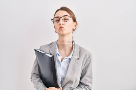 Foto de Young caucasian woman wearing business clothes and glasses looking at the camera blowing a kiss on air being lovely and sexy. love expression. - Imagen libre de derechos
