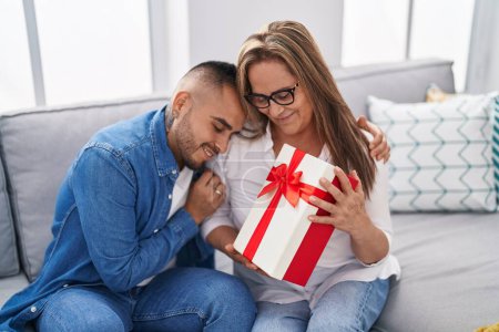 Téléchargez les photos : Homme et femme mère et fils surprise avec cadeau étreinte à la maison - en image libre de droit