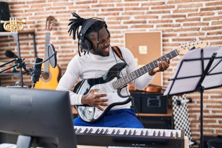 Téléchargez les photos : Artiste afro-américaine chantant une chanson jouant de la guitare électrique au studio de musique - en image libre de droit