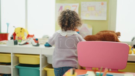 Photo for Adorable hispanic girl standing on back view at kindergarten - Royalty Free Image