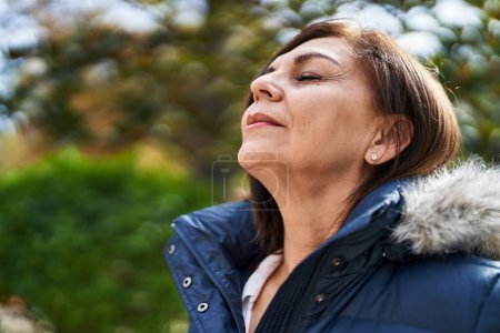 Photo for Middle age woman breathing with closed eyes at park - Royalty Free Image