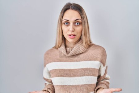 Photo for Young blonde woman wearing turtleneck sweater over isolated background clueless and confused with open arms, no idea concept. - Royalty Free Image
