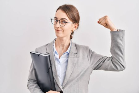 Photo for Young caucasian woman wearing business clothes and glasses strong person showing arm muscle, confident and proud of power - Royalty Free Image