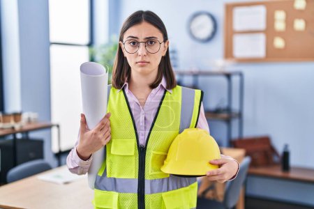 Photo for Hispanic girl architect holding build project blueprints skeptic and nervous, frowning upset because of problem. negative person. - Royalty Free Image
