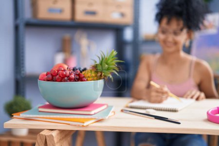 Photo for Young hispanic woman artist drawing fruit bowl on notebook at art studio - Royalty Free Image