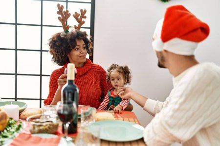 Téléchargez les photos : Couple and daughter smiling confident having christmas dinner at home - en image libre de droit