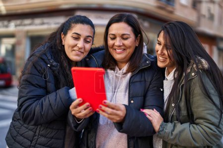 Photo for Three woman mother and daughters having video call at street - Royalty Free Image