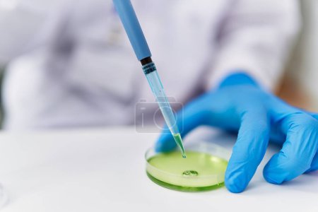 Photo for Young hispanic man wearing scientist uniform using pipette at laboratory - Royalty Free Image