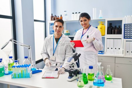 Photo for Young doctors working at scientist laboratory smiling happy pointing with hand and finger - Royalty Free Image