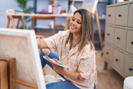 Téléchargez les photos : Young hispanic woman artist smiling confident drawing at art studio - en image libre de droit