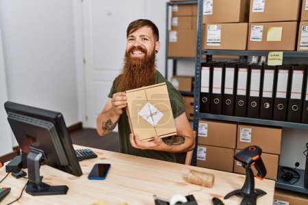 Photo for Young redhead man business worker holding package at office - Royalty Free Image