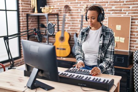 Téléchargez les photos : Femme musicienne afro-américaine ayant une session de DJ au studio de musique - en image libre de droit