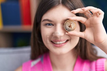 Photo for Young caucasian woman smiling confident holding uniswap coin over eye at home - Royalty Free Image