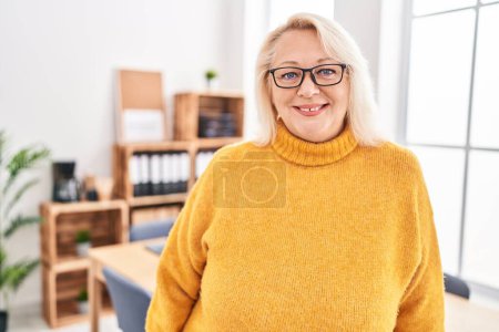 Photo for Middle age blonde woman business worker smiling confident standing at office - Royalty Free Image