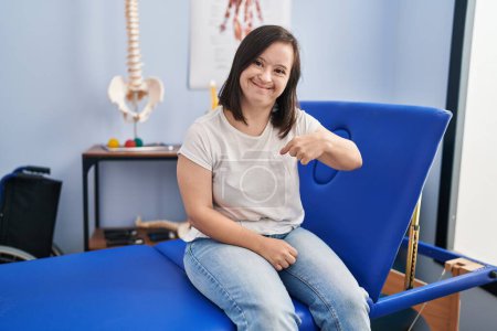 Photo for Hispanic girl with down syndrome at physiotherapy clinic pointing finger to one self smiling happy and proud - Royalty Free Image
