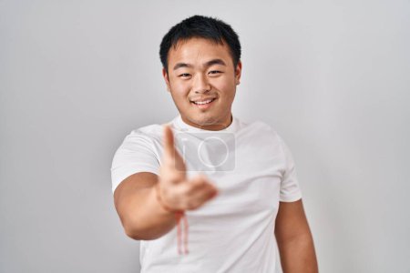 Téléchargez les photos : Jeune homme chinois debout sur fond blanc souriant joyeuse offrant main de paume donnant assistance et acceptation. - en image libre de droit