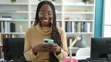 Téléchargez les photos : African woman smiling using smartphone at library university - en image libre de droit