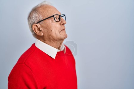 Photo for Senior man with grey hair standing over isolated background looking to side, relax profile pose with natural face and confident smile. - Royalty Free Image