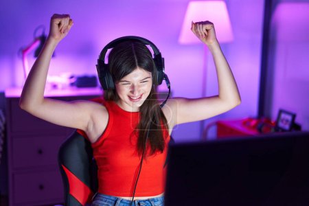 Photo for Young caucasian woman streamer playing video game with winner expression at gaming room - Royalty Free Image