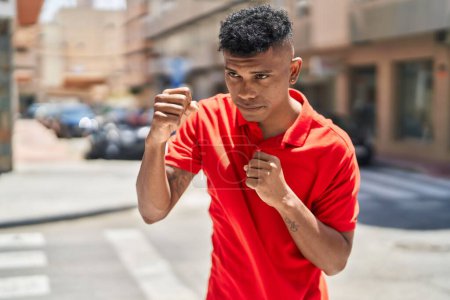 Téléchargez les photos : Jeune homme latin boxe dans la rue - en image libre de droit
