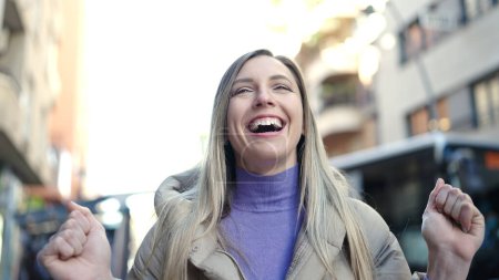 Téléchargez les photos : Young blonde woman smiling confident standing with winner expression at street - en image libre de droit