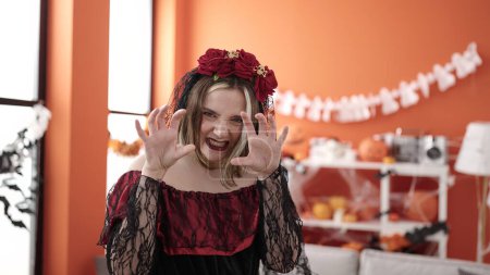 Foto de Joven mujer rubia con disfraz de katrina haciendo gesto de miedo en casa - Imagen libre de derechos