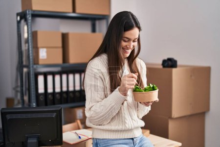 Téléchargez les photos : Young woman ecommerce business worker eating salad at office - en image libre de droit