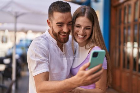 Téléchargez les photos : Man and woman couple smiling confident using smartphone at street - en image libre de droit