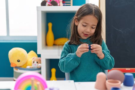 Photo for Adorable hispanic girl playing with toys standing at kindergarten - Royalty Free Image