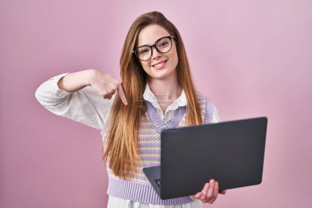 Photo for Young caucasian woman working using computer laptop looking confident with smile on face, pointing oneself with fingers proud and happy. - Royalty Free Image