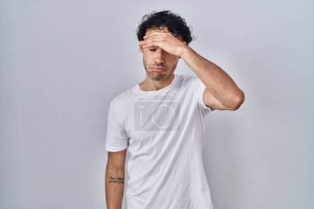 Photo for Hispanic man standing over isolated background worried and stressed about a problem with hand on forehead, nervous and anxious for crisis - Royalty Free Image