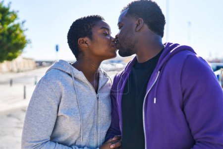 Téléchargez les photos : Couple homme et femme portant des vêtements de sport s'embrassant dans la rue - en image libre de droit
