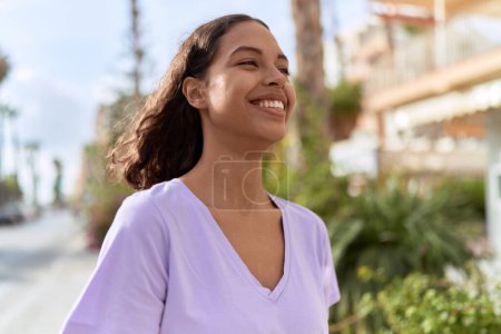 Téléchargez les photos : Young african american woman smiling confident looking to the side at street - en image libre de droit