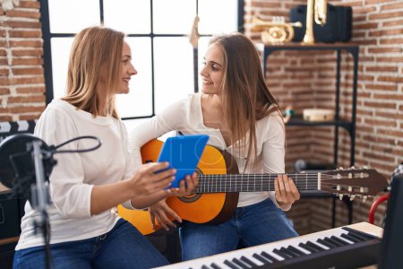 Foto de Dos mujeres músicos que tienen clases de guitarra clásica en el estudio de música - Imagen libre de derechos
