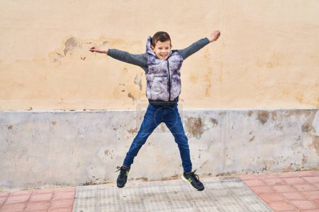 Photo for Blond child smiling confident jumping at street - Royalty Free Image